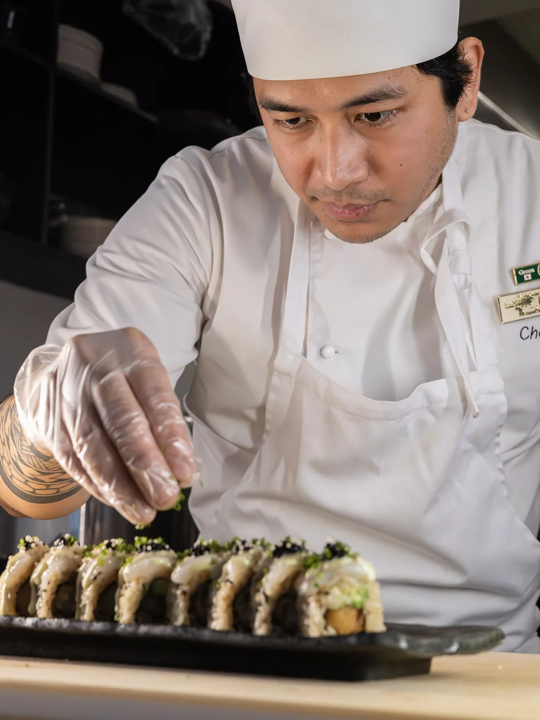 Chef at Sushi Roll Sandviken plating a roll